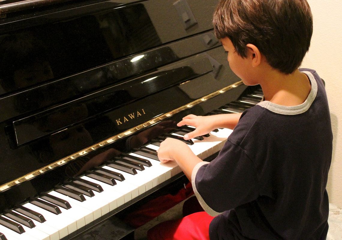 Junge spielt am Klavier