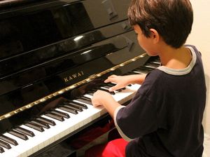 Junge spielt am Klavier